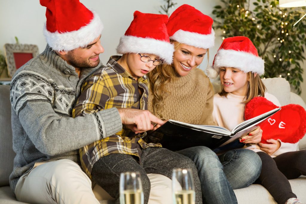 Família feliz e alegre na noite de natal olhando álbum de fotos